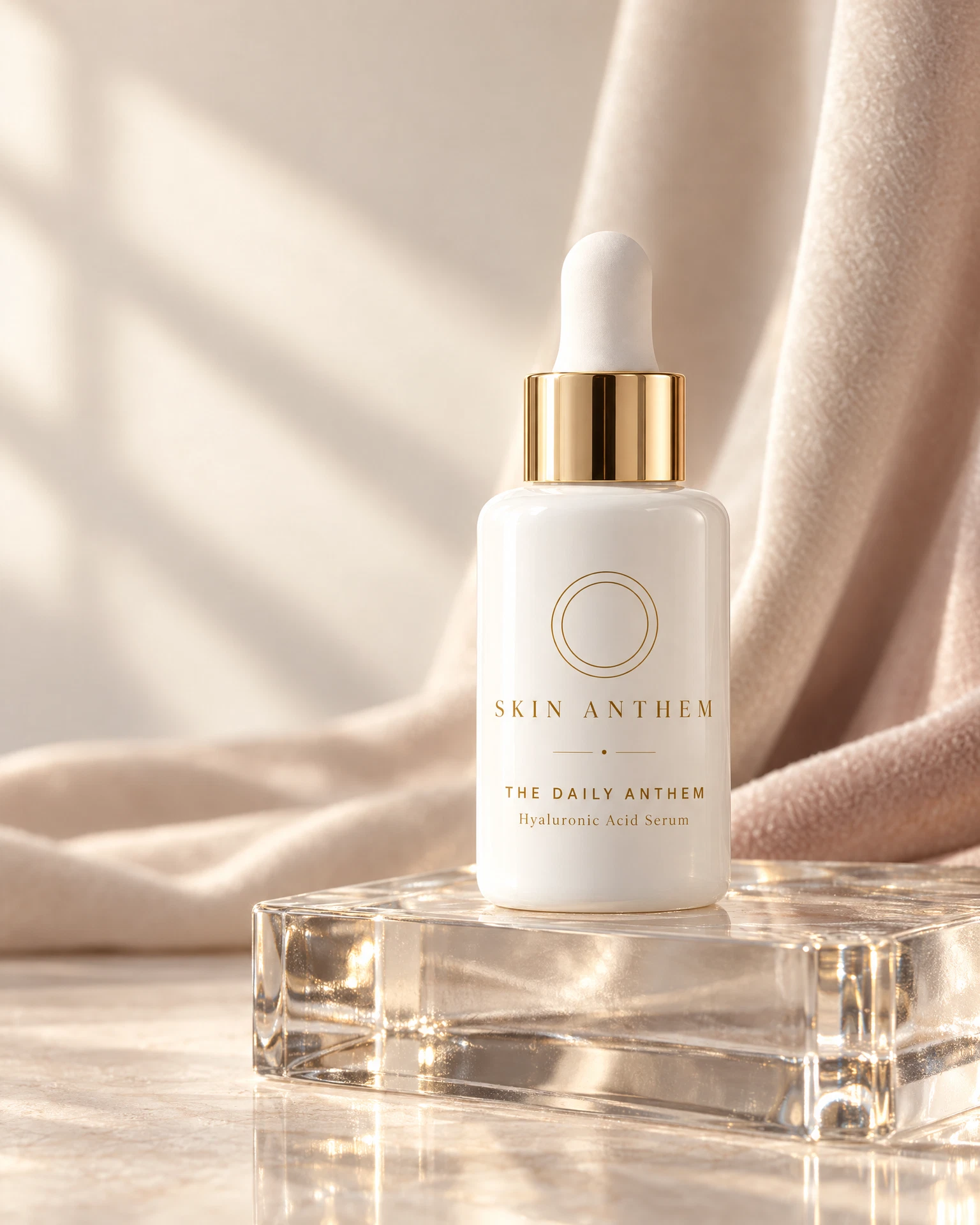 White serum bottle with gold collar on a glass block.